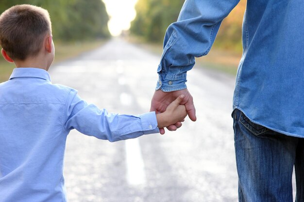 Foto pais felizes com uma criança no parque, mãos na natureza, viajam pela estrada.