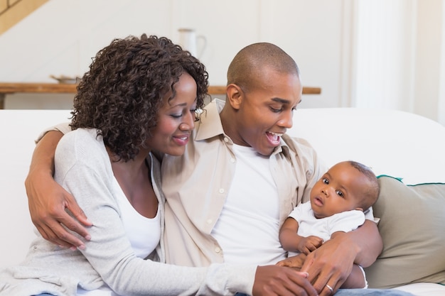 Pais felizes passando tempo com o bebê no sofá