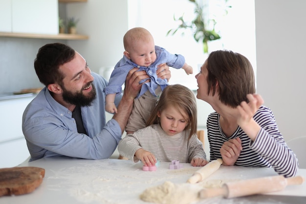 Pais jovens brincando com crianças na cozinha