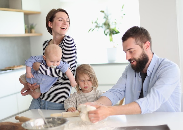 Pais jovens brincando com crianças na cozinha