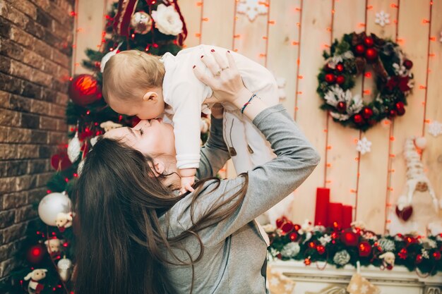 Pais jovens com filho perto da árvore de Natal