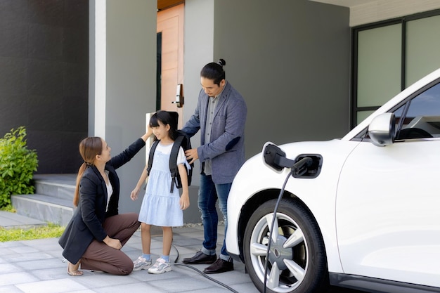 Pais jovens progressistas e filha morando em uma casa com carro elétrico