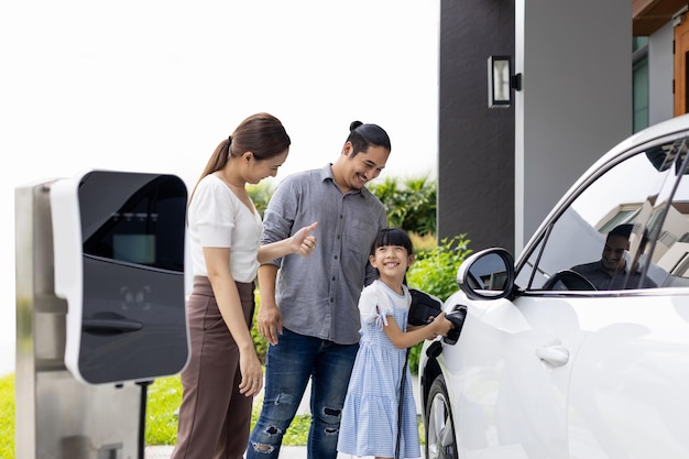 Pais jovens progressistas e filha morando em uma casa com carro elétrico