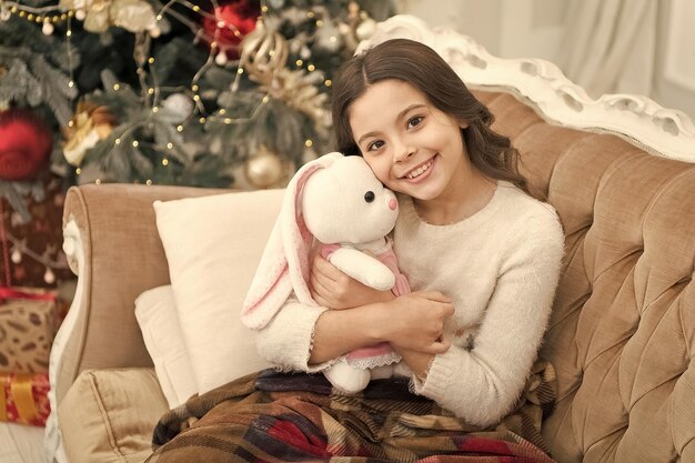 País de las maravillas de invierno La mejor época del año Niña adorable juega con juguetes en la víspera de Navidad Concepto acogedor Niño sonriente disfruta de las vacaciones de invierno Vacaciones de invierno Decoraciones de invierno Atmósfera mágica