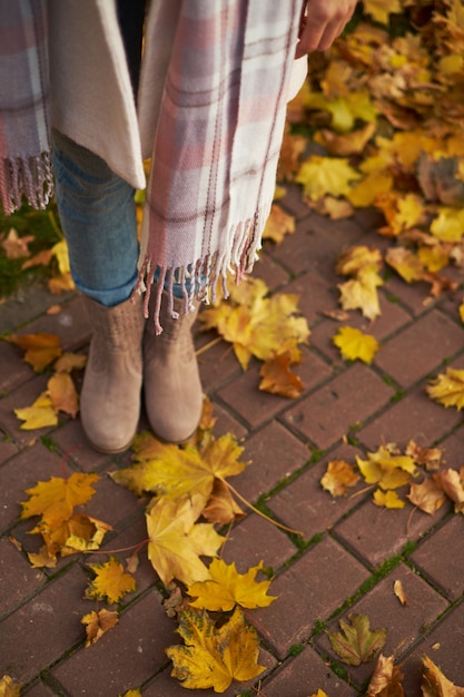 Foto país de otoño - una mujer vestida con botas de ante, con bufanda larga.