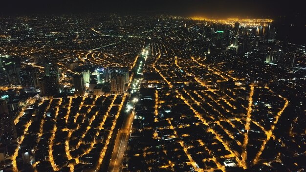 Paisagem aérea da cidade à noite Ruas iluminadas de Manila no centro da cidade na rota de tráfego Transportes urbanos