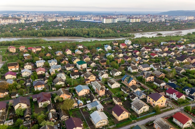 Paisagem aérea da pequena cidade ou vila com fileiras de casas residenciais e árvores verdes.