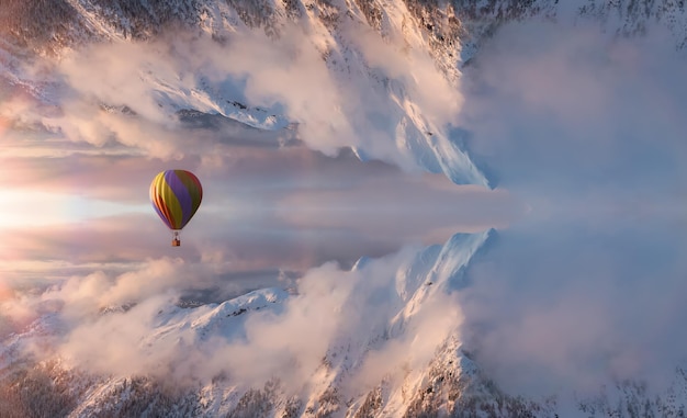 Paisagem aérea de fantasia mágica com um balão de ar quente espelhado do mundo da montanha voando