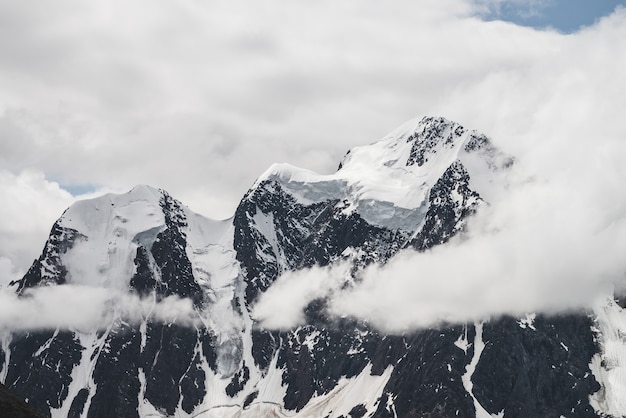 Paisagem alpina minimalista atmosférica com enorme geleira suspensa no pico de uma montanha de neve. Grande varanda serac na borda glacial. Nuvens baixas entre montanhas cobertas de neve. Cenário majestoso em alta altitude.