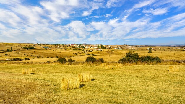 Paisagem após a colheita com a aldeia de agricultores em segundo plano.