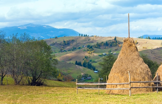 Paisagem campestre de outono com vila na encosta da montanha