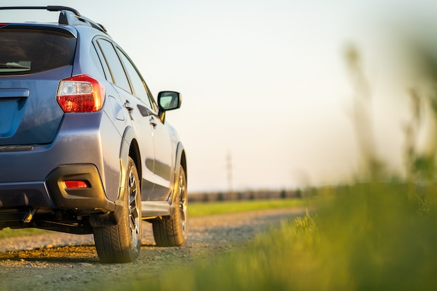 Paisagem com carro azul off road na estrada de cascalho. viajar de automóvel, aventura na vida selvagem, expedição ou viagem extrema em um automóvel suv. veículo 4x4 offroad no campo ao nascer do sol.