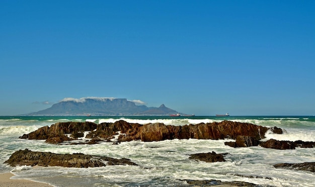 paisagem com pedras na praia e Table Mountain ao fundo