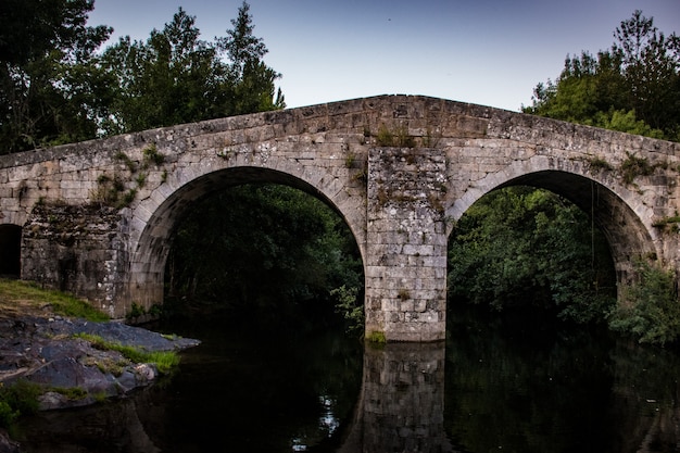 Paisagem com ponte romana sobre o rio de águas calmas