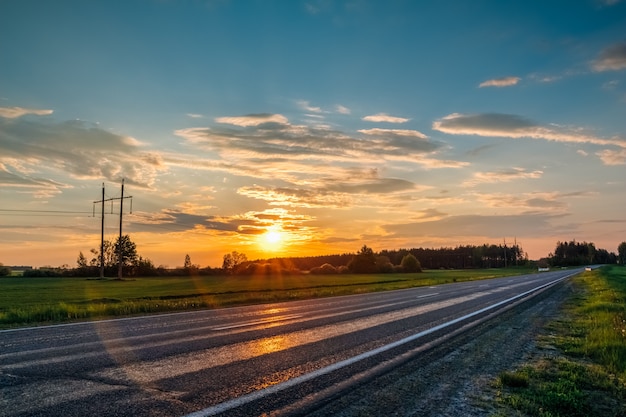 Paisagem com pôr do sol laranja ao longo da estrada