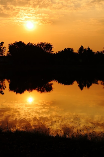 Paisagem com pôr do sol sobre o lago com reflexo na superfície da água