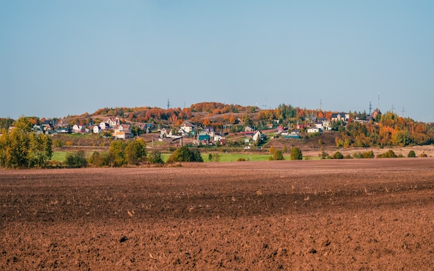 Foto paisagem com terreno agrícola com uma vila ao fundo