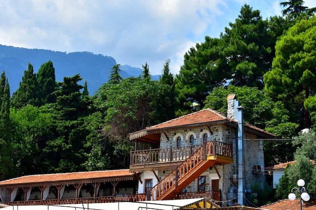 Paisagem com uma casa de estilo tártaro com um telhado vermelho árvores e montanhas Hurzuf Gurzuf Crimeia