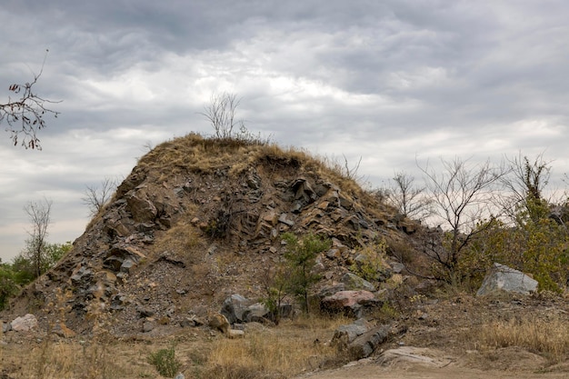 Paisagem com uma rocha de granito de pedra contra um céu nublado