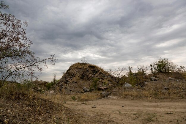 Paisagem com uma rocha de granito de pedra contra um céu nublado