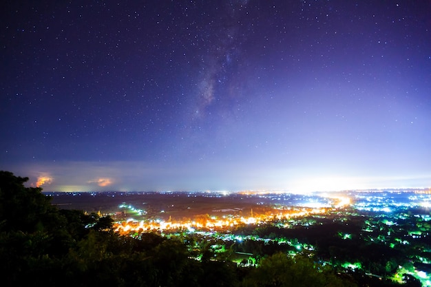 Paisagem da cidade à noite com a Via Láctea fotografia de longa exposição