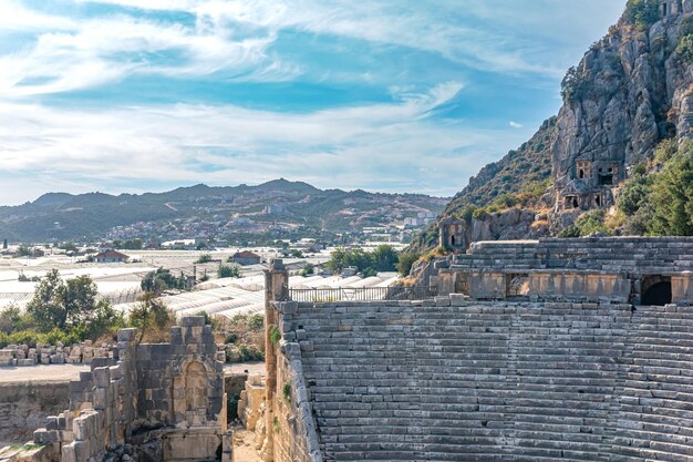 Foto paisagem da cidade de demre, na turquia, túmulos rochosos da antiga myra e modernas estufas agrícolas