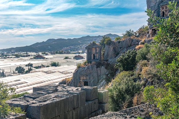 Foto paisagem da cidade de demre, na turquia, túmulos rochosos da antiga myra e modernas estufas agrícolas