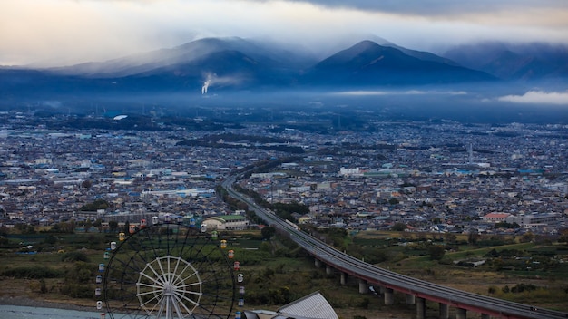 Paisagem da cidade na tempestade de manhã no fundo do céu da nuvem da montanha da estação chuvosa no japão