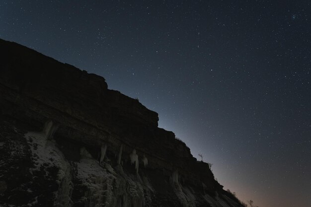 Foto paisagem da estônia no penhasco de paldiski em uma noite de inverno com um céu claro com estrelas