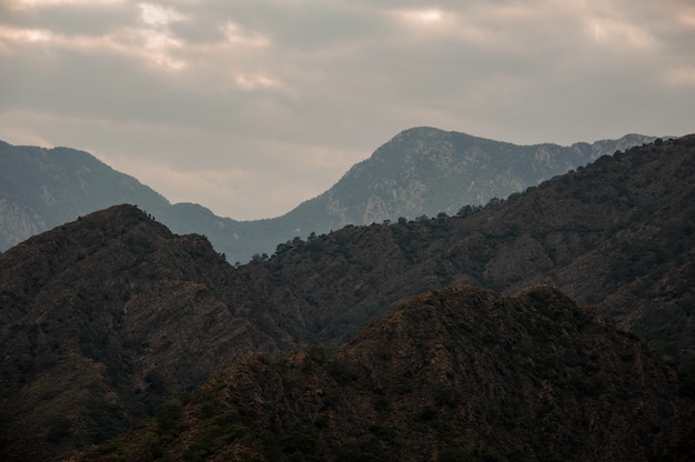 Paisagem da montanha sob o céu nublado com luz