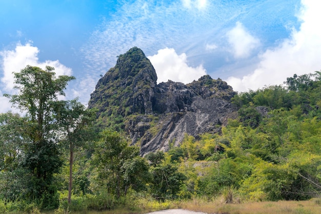 Paisagem da velha montanha de pedra de mineração com floresta verde fresca e céu azul brilhante nublado em Thong Pha Phum, Kanchanaburi, Tailândia. colina de calcário. viagem de aventura na natureza.