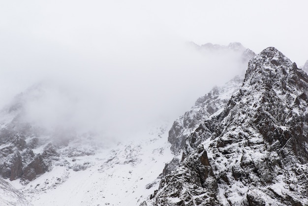 Paisagem das montanhas rochosas de inverno com nevoeiro