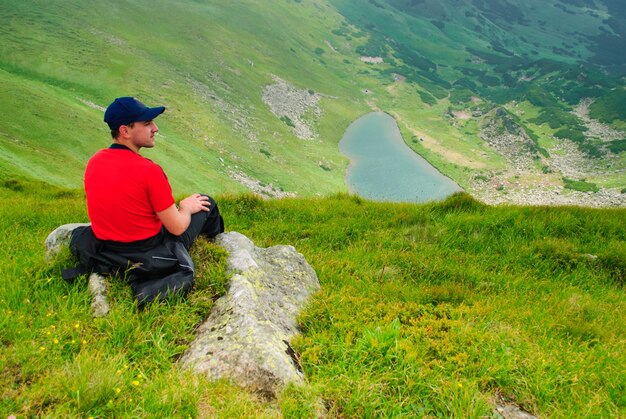 Paisagem de belas montanhas com lago e nuvens nas montanhas dos Cárpatos e aparência de homem