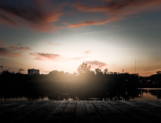 Foto paisagem de cais de madeira com dramatico nascer do sol no céu acima da lagoa