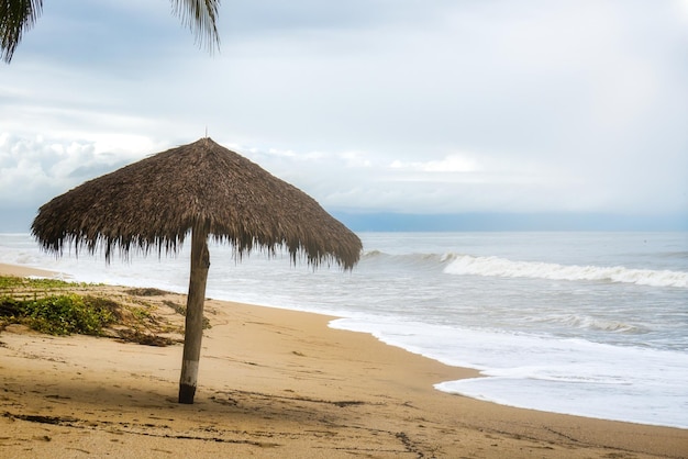 Paisagem de fundo com guarda-chuva de folhas de palmeira na praia