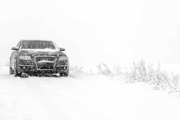 Paisagem de inverno com estrada e carro preto