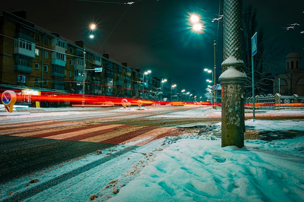 Paisagem de inverno com luzes noturnas. Rua coberta de neve de uma cidade moderna