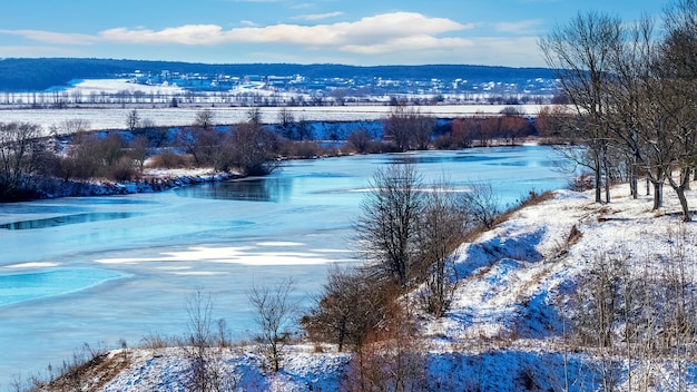 Paisagem de inverno com rio e árvores nas rochas