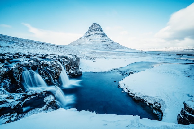 Paisagem de inverno com sol nascente na cachoeira Kirkjufellsfoss e montanha Kirkjufell Islândia Europa