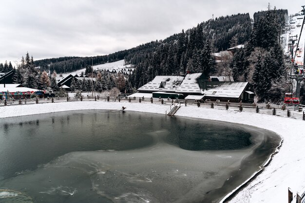 Paisagem de inverno nevando com o lago congelado nas montanhas. Superfície congelada da água. Conceito de temporada de inverno