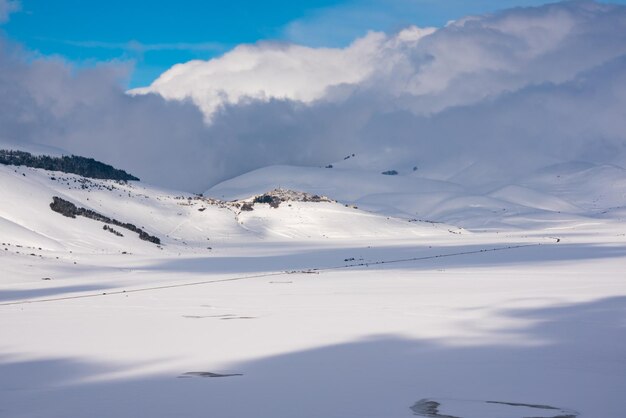 Paisagem de inverno pequena cidade em uma colina em um vale coberto de neve
