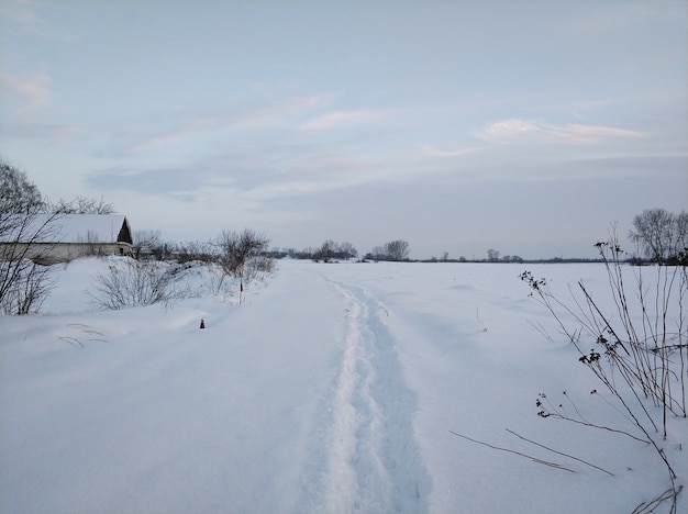 Paisagem de inverno. Uma aldeia distante na parte fria do planeta. Estrada coberta de neve branca.