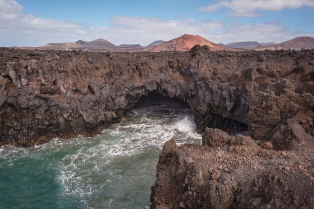 Paisagem de lanzarote. litoral, cavernas de lava, falésias e oceano ondulado.