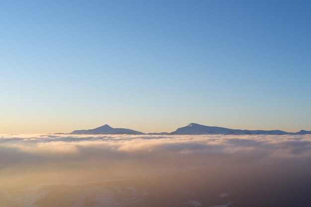 Paisagem de manhã no inverno. picos de montanhas nas nuvens. cárpatos, ucrânia, europa