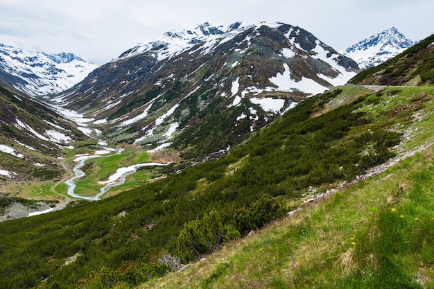 Paisagem de montanha Alpes de verão com estrada alpina e rio (Fluela Pass, Suíça).