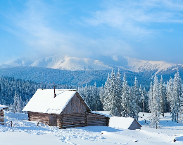 Paisagem de montanha calma de inverno com galpão e cume de montagem atrás das montanhas Kukol Mount Carpathian Ucrânia