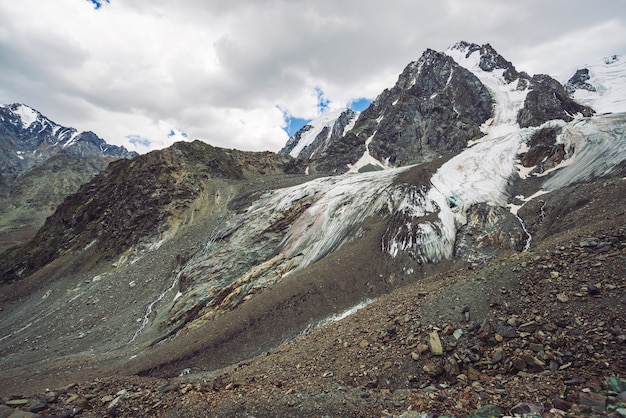 Paisagem de montanha com geleira no topo da montanha e córregos de água derretida em talus