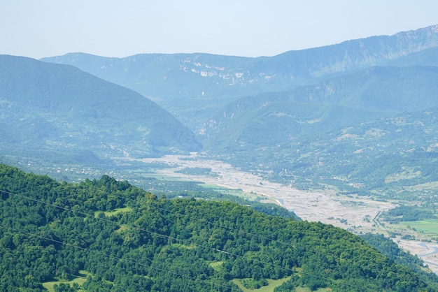 Paisagem de montanha georgiana com uma estrada rural com vista para as florestas