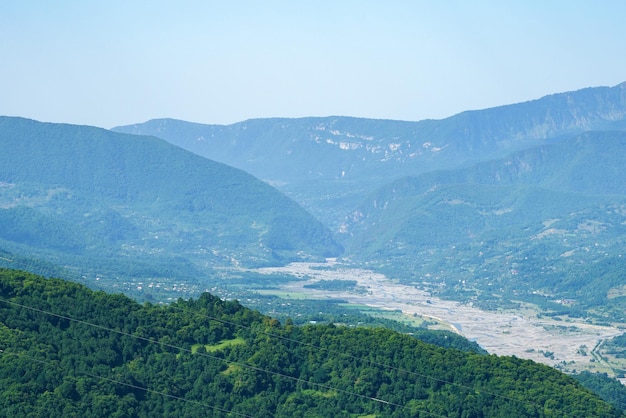 Paisagem de montanha georgiana com uma estrada rural com vista para as florestas