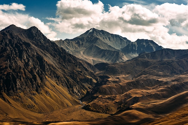 Paisagem de montanha incrivelmente bela. Picos das montanhas ao sol. Vista panorâmica das montanhas de outono. Paisagem com vista para os vales das montanhas. Vista superior do desfiladeiro da montanha. Copie o espaço